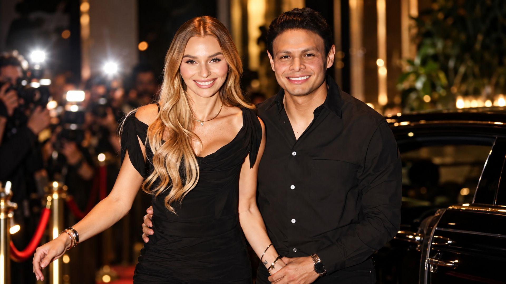 Irina Baeva posa junto a un hombre en una composición editorial con fotógrafos y luces de un evento nocturno.